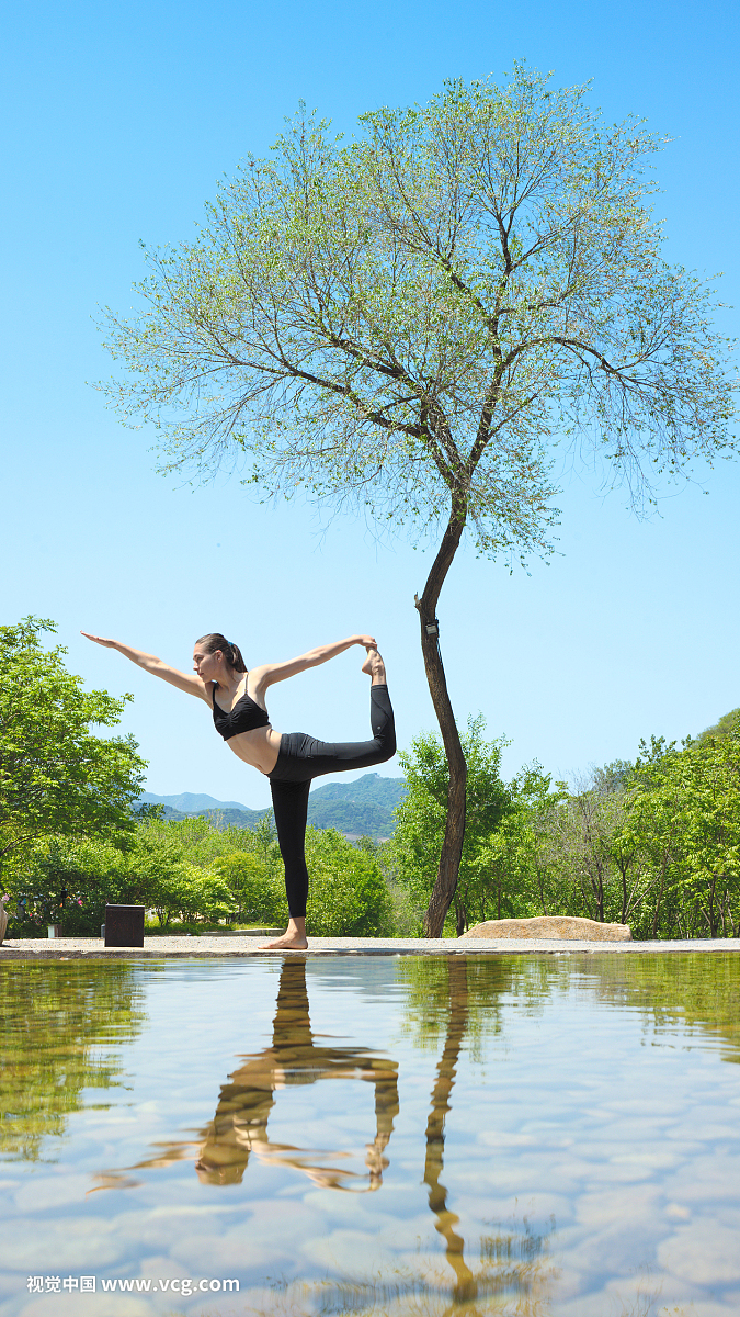 一个年轻女人在水边练习瑜伽舞蹈式